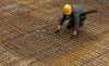 Photo of a construction worker laying out rebar